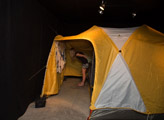 Camp Up To Now installation by Ayin Es, exterior of tent at Shulamit Gallery of person reading wall of field notes