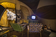 Camp Up To Now installation by Ayin Es, interior tent with tv, car battery, ants, snake and Torah at Shulamit Gallery